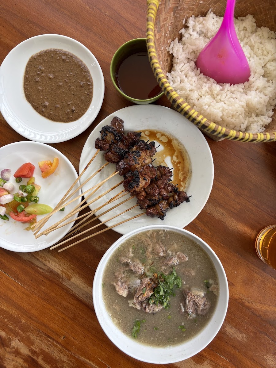 Satu meja hidangan Sate Kambing Hanjawar: sate, nasi bakul, sop kambing, dan sambal segar