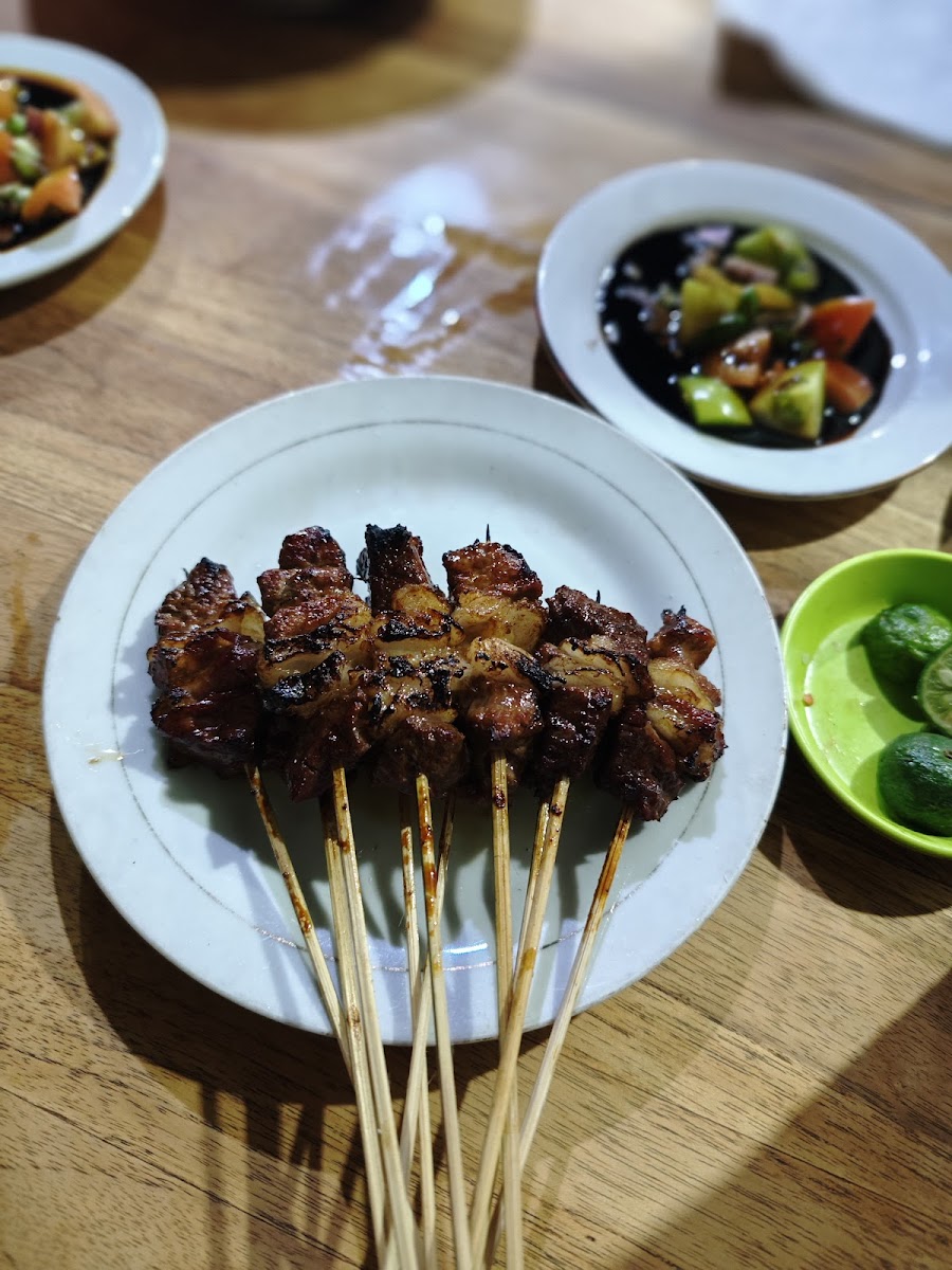 Tusukan sate kambing bakar dengan sambal kecap dan irisan jeruk nipis