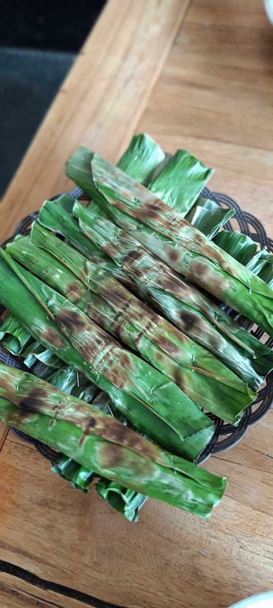Hidangan dibakar dalam bungkusan daun pisang di atas piring anyaman
